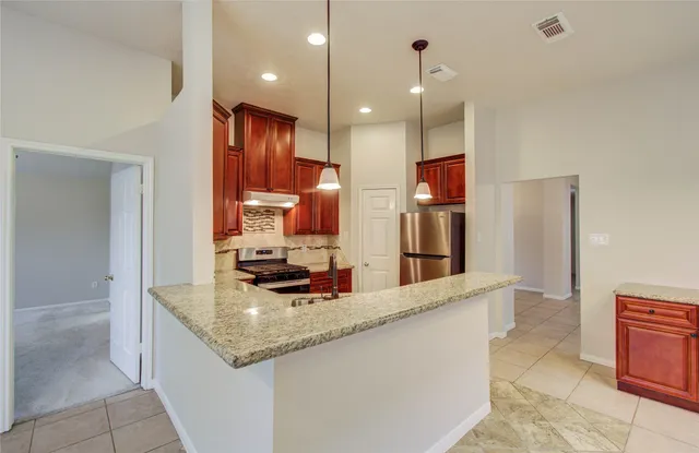 a kitchen with stainless steel appliances granite countertop a sink and a refrigerator