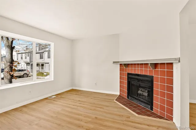 a view of an empty room with a fireplace and a window