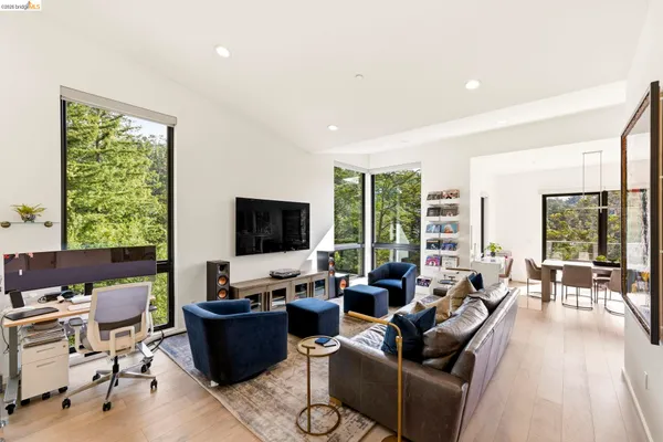 a living room with furniture a flat screen tv and a floor to ceiling window