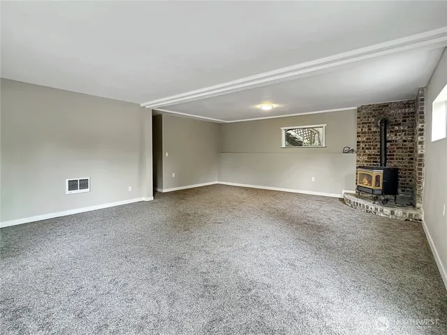 an empty room with windows and fireplace