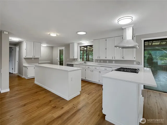 a kitchen with kitchen island a sink and a stove top oven
