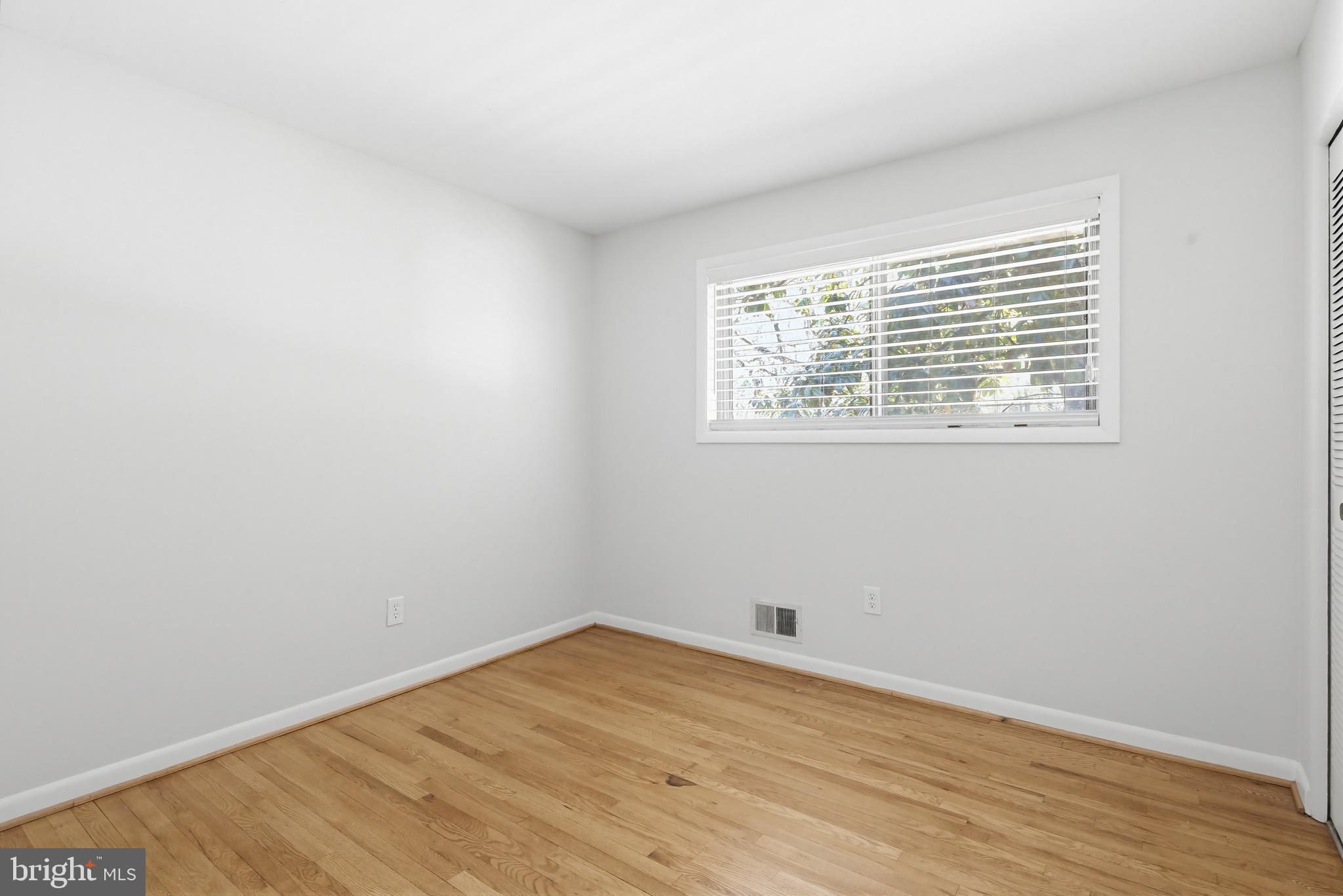 9717 Hedin Drive Silver Spring, MD 20903 - Photo 21 of 36 an empty room with wooden floor and a window