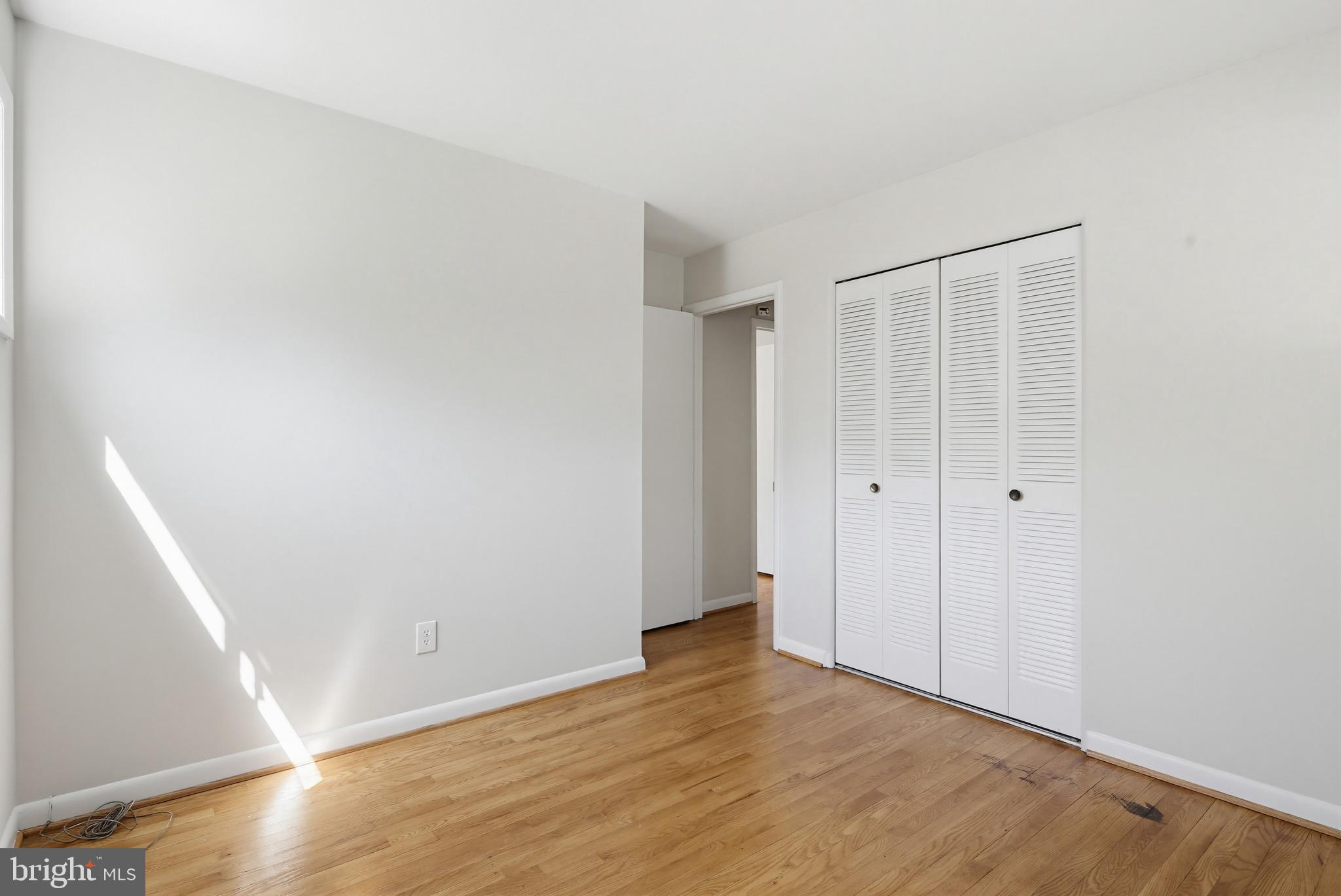 9717 Hedin Drive Silver Spring, MD 20903 - Photo 24 of 36 a view of an empty room with wooden floor and a window