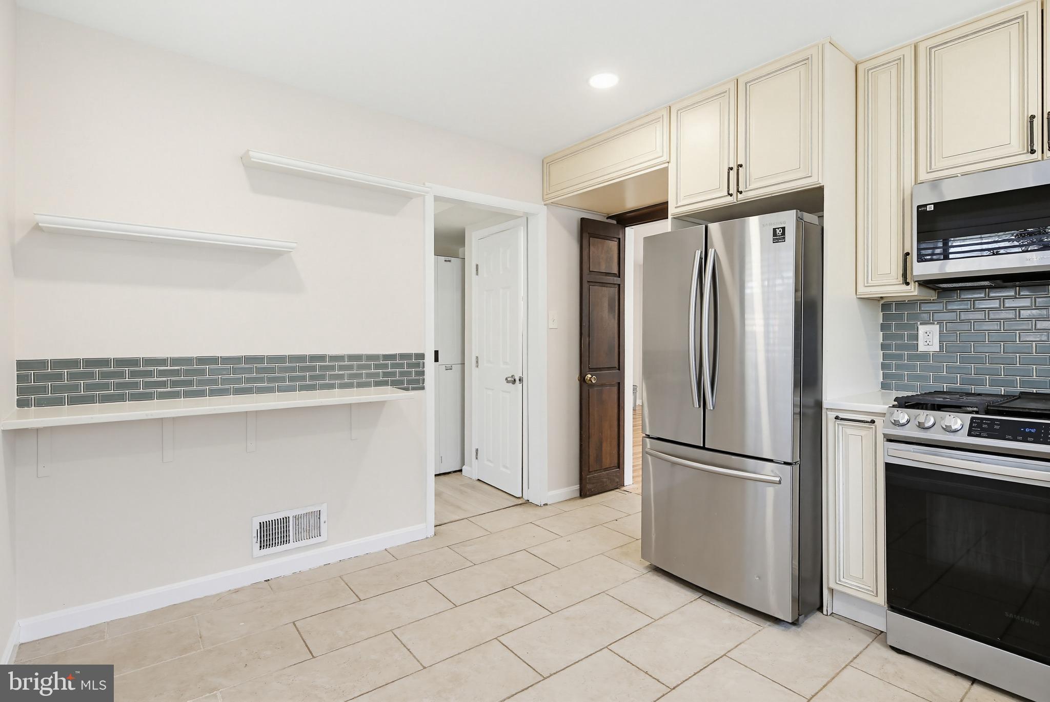 9717 Hedin Drive Silver Spring, MD 20903 - Photo 3 of 36 a kitchen with stainless steel appliances a refrigerator and a stove top oven