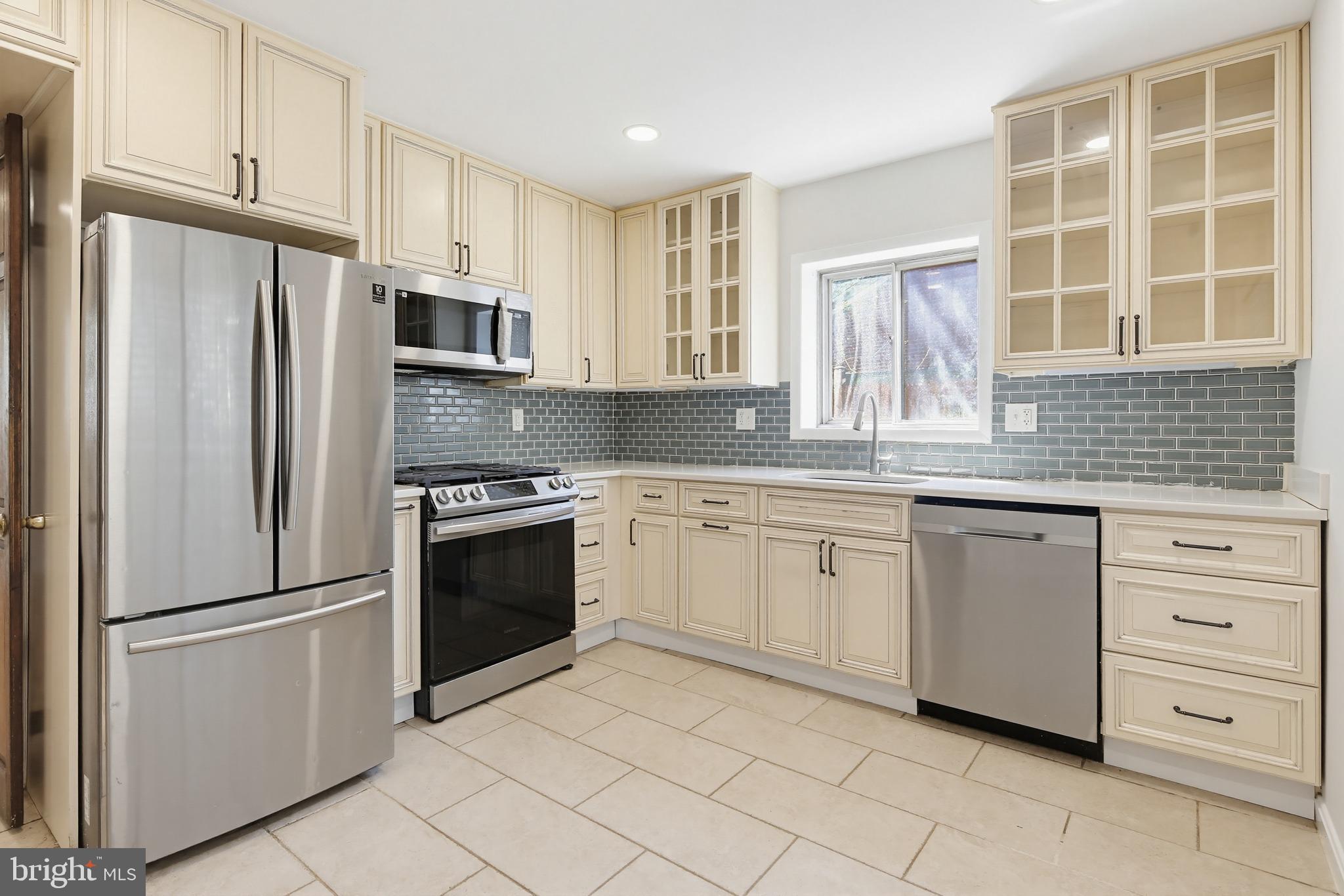 9717 Hedin Drive Silver Spring, MD 20903 - Photo 4 of 36 a kitchen with granite countertop white cabinets and stainless steel appliances