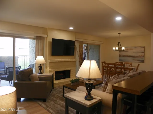a living room with furniture a flat screen tv and a fireplace