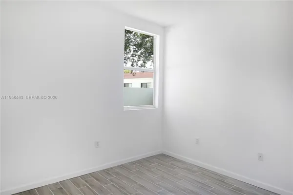 a view of a small space with wooden floor and a window