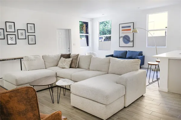 a living room with furniture and a wooden floor