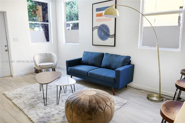 a living room with furniture and a painting on the wall
