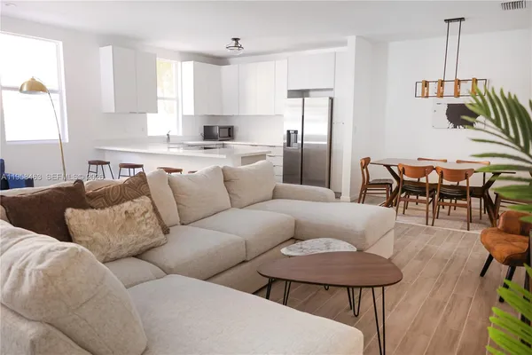 a living room with furniture a refrigerator and a dining table