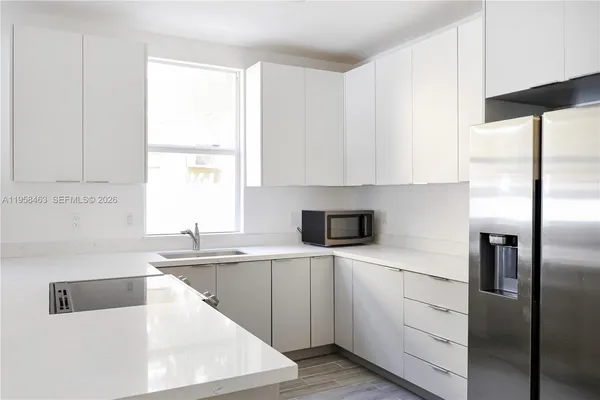 a kitchen with a sink a refrigerator and window