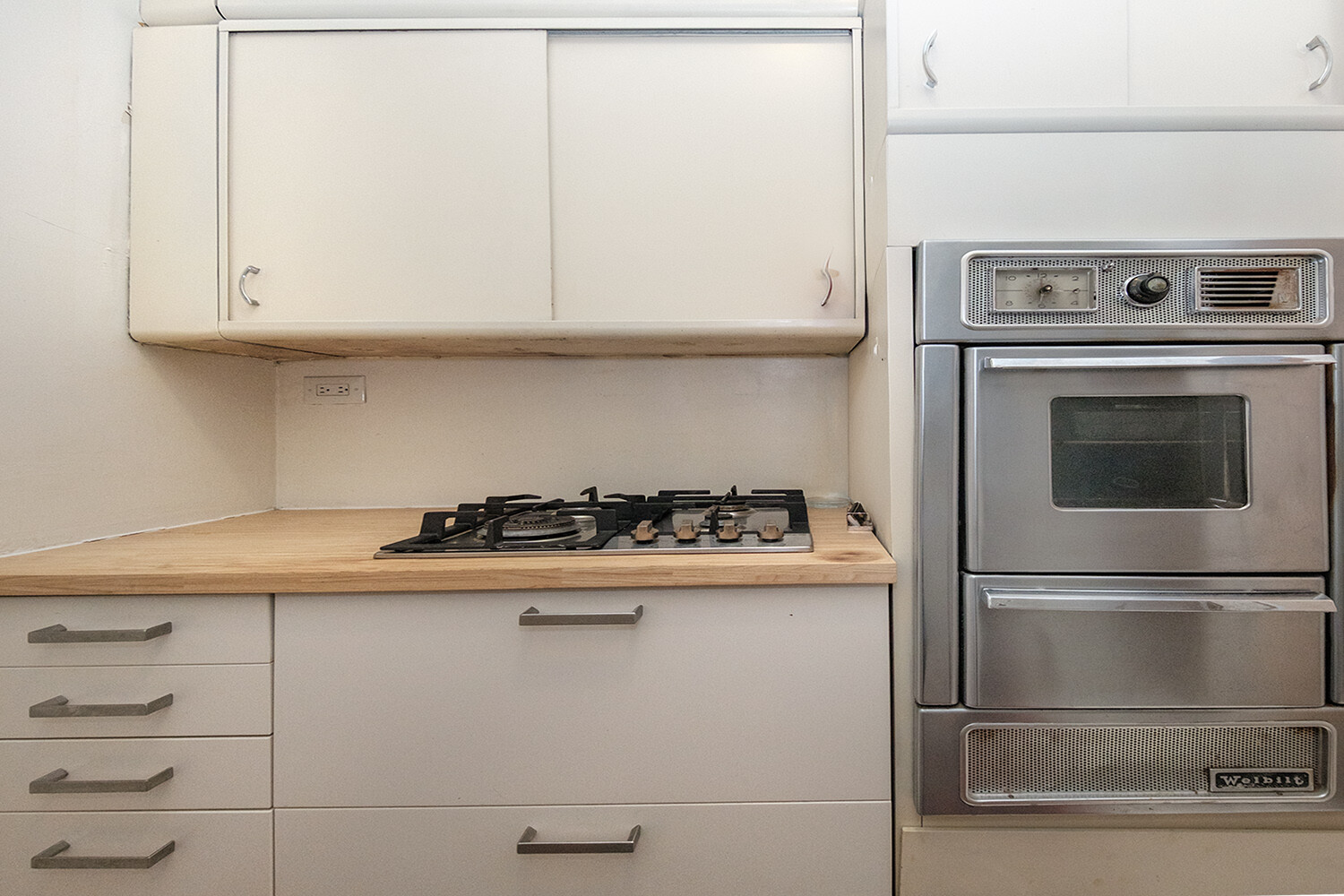 25 East 69th Street, Unit 5B Manhattan, NY 10021 - Photo 10 of 22 a kitchen with granite countertop white cabinets and stainless steel appliances