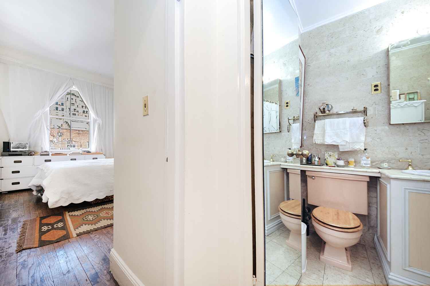 25 East 69th Street, Unit 5B Manhattan, NY 10021 - Photo 11 of 22 a bathroom with a toilet sink and mirror