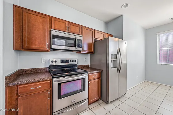 a view of an empty room with chandelier fan