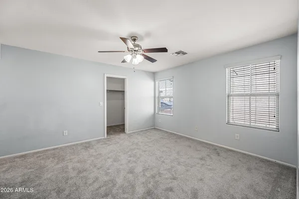 an empty room with a window and a fan