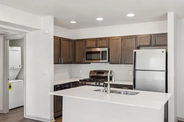 a kitchen with stainless steel appliances a refrigerator sink and microwave