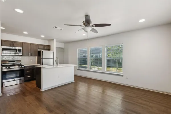 a kitchen with stainless steel appliances a refrigerator and a stove top oven