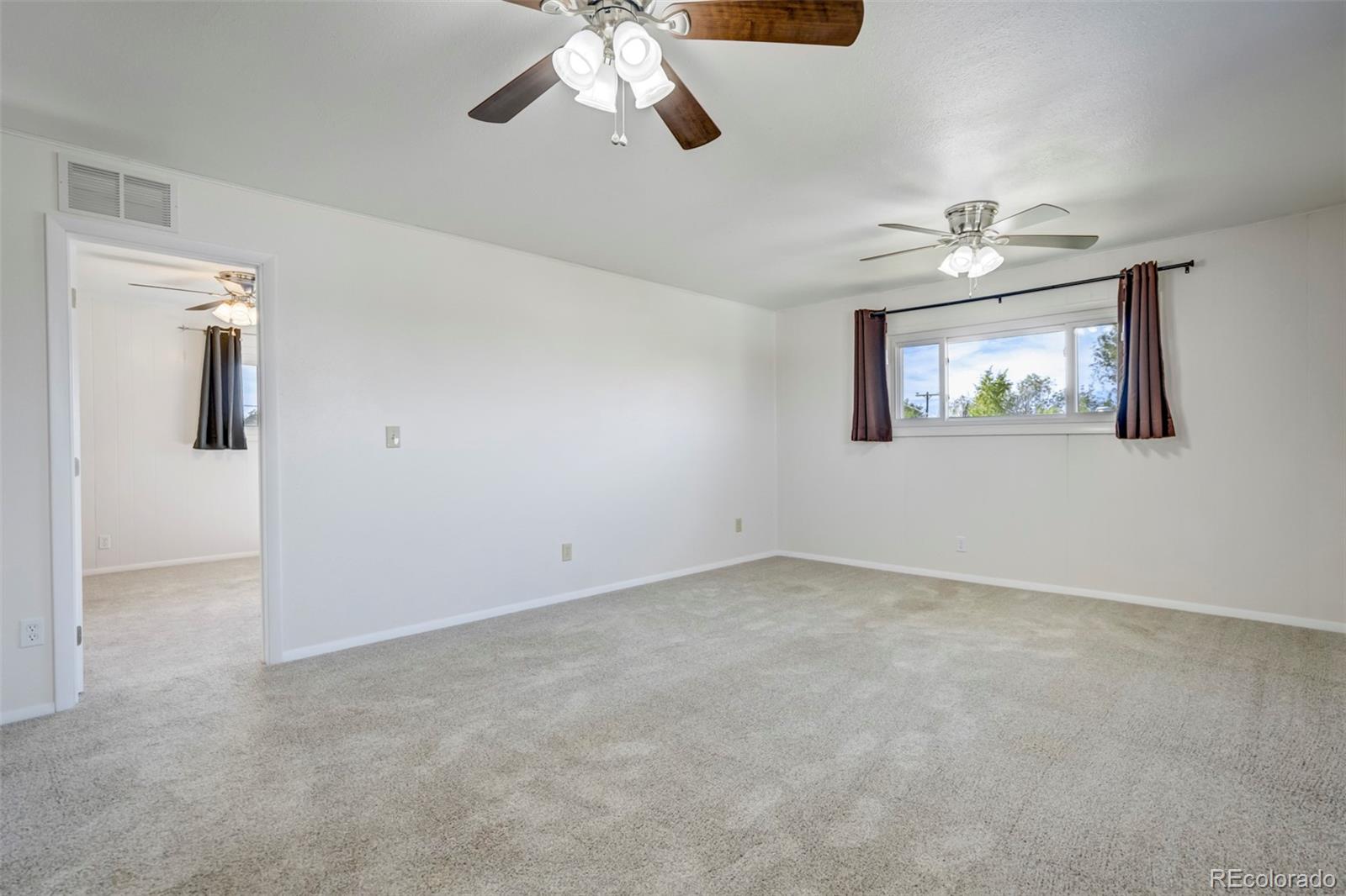 1284 Thompson Street Limon, CO 80828 - Photo 15 of 49 en empty room with windows and fan