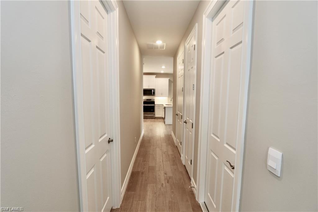 1063 Enbrook Loop Naples, FL 34114 - Photo 13 of 26 a view of a hallway with wooden floor and staircase