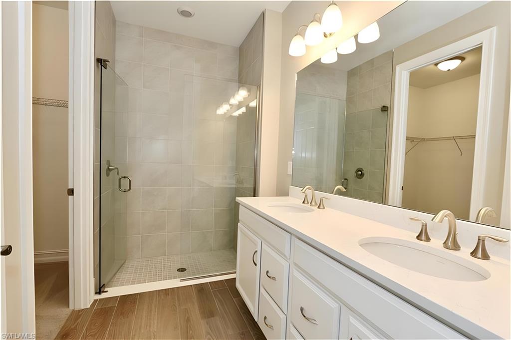 1063 Enbrook Loop Naples, FL 34114 - Photo 16 of 26 a bathroom with a double vanity sink mirror and shower