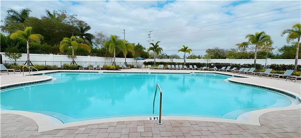1063 Enbrook Loop Naples, FL 34114 - Photo 22 of 26 a view of a swimming pool with a lawn chairs under an umbrella