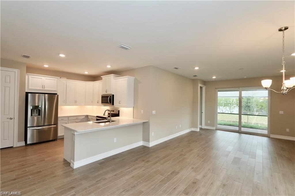 1063 Enbrook Loop Naples, FL 34114 - Photo 6 of 26 a kitchen with stainless steel appliances granite countertop a refrigerator and a stove top oven