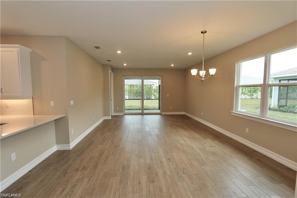 1063 Enbrook Loop Naples, FL 34114 - Photo 8 of 26 an empty room with wooden floor and windows