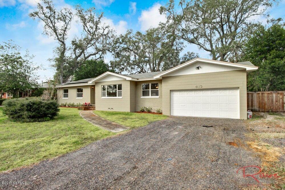 a view of a house with a yard and large tree