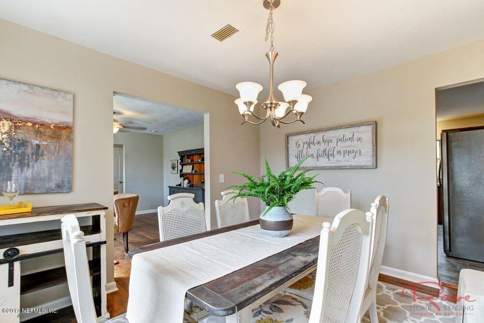 413 Baisden Road Jacksonville, FL 32218 - Photo 17 of 31 a dining room with furniture potted plants and wooden floor