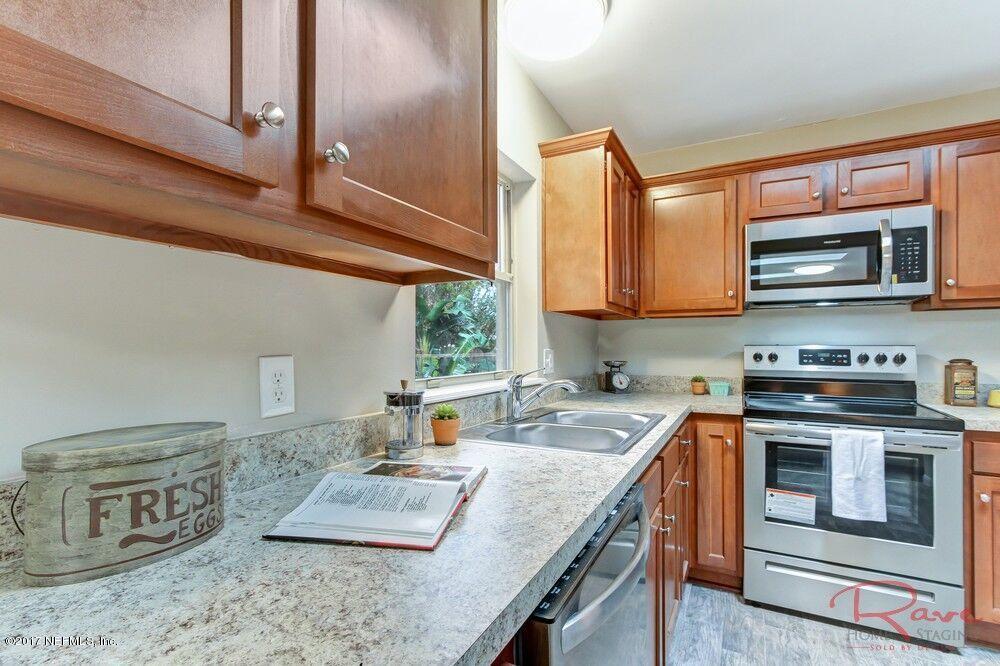413 Baisden Road Jacksonville, FL 32218 - Photo 21 of 31 a kitchen with stainless steel appliances granite countertop a stove a sink and a microwave