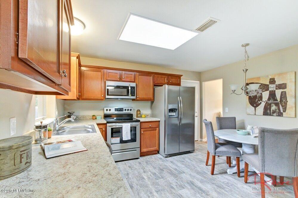 413 Baisden Road Jacksonville, FL 32218 - Photo 22 of 31 a kitchen with stainless steel appliances a stove a sink dishwasher and a refrigerator with wooden floor