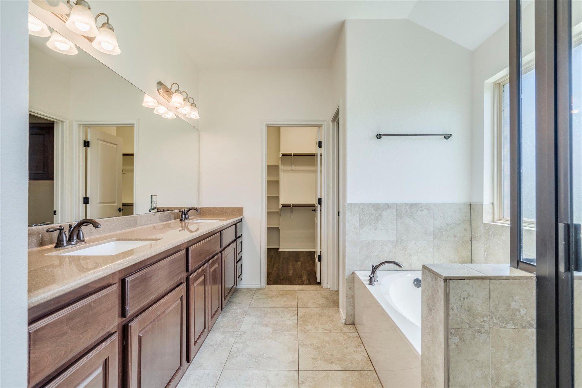 16829 Ruggio Road Pflugerville, TX 78660 - Photo 20 of 40 a spacious bathroom with a granite countertop sink a mirror and shower