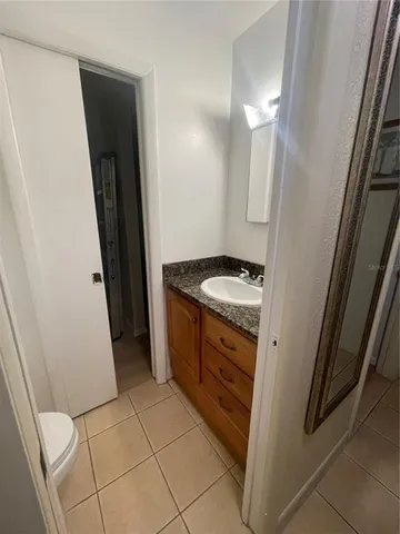 a bathroom with a granite countertop sink and a mirror