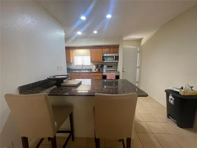 a kitchen with kitchen island a sink table and chairs