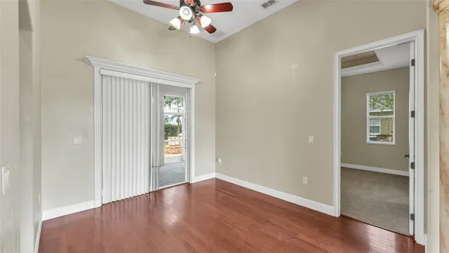 an empty room with wooden floor and windows