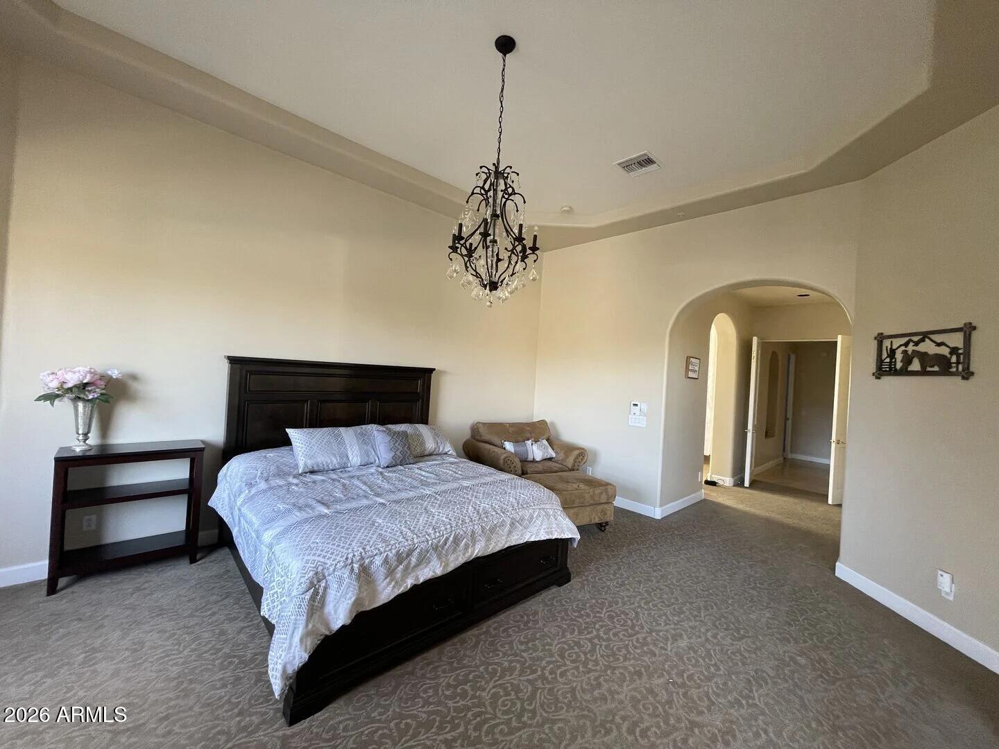 12198 East Doubletree Ranch Road Scottsdale, AZ 85259 - Photo 20 of 70 a bedroom with a bed and a chandelier