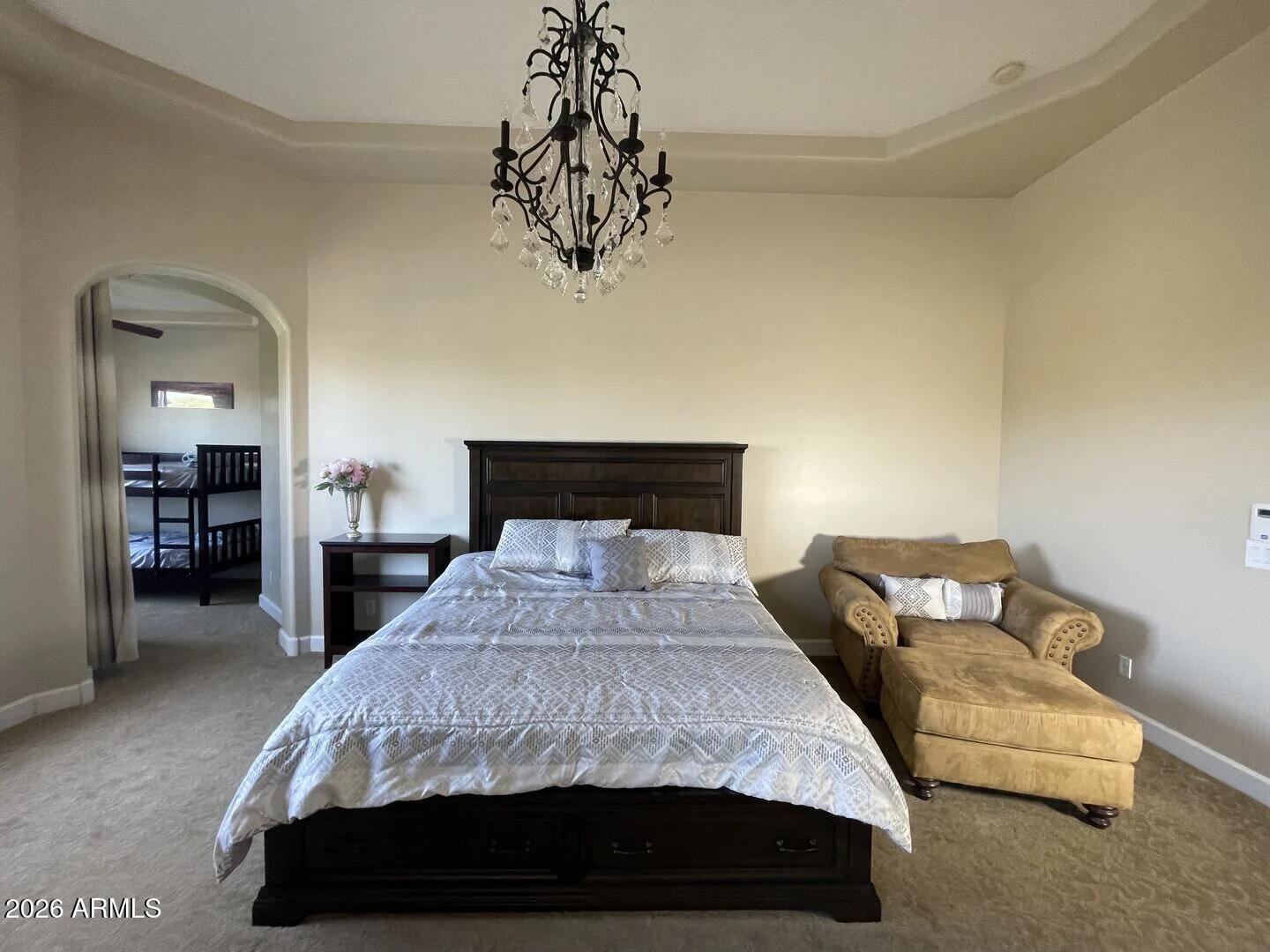 12198 East Doubletree Ranch Road Scottsdale, AZ 85259 - Photo 21 of 70 a bedroom with a large bed and a chandelier