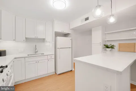 a kitchen with appliances a sink and cabinets