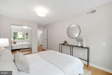 a bedroom with a bed a mirror and lamp