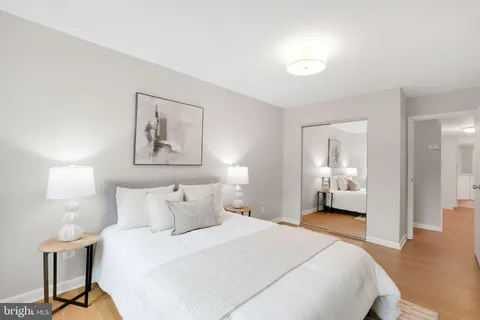 a bedroom with a bed and a painting on the wall