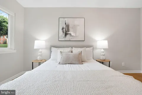a bedroom with a bed and a painting on the wall