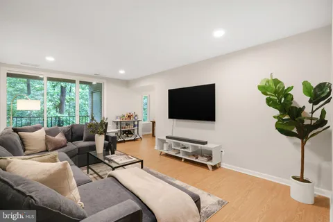 a living room with furniture floor to ceiling window and a flat screen tv