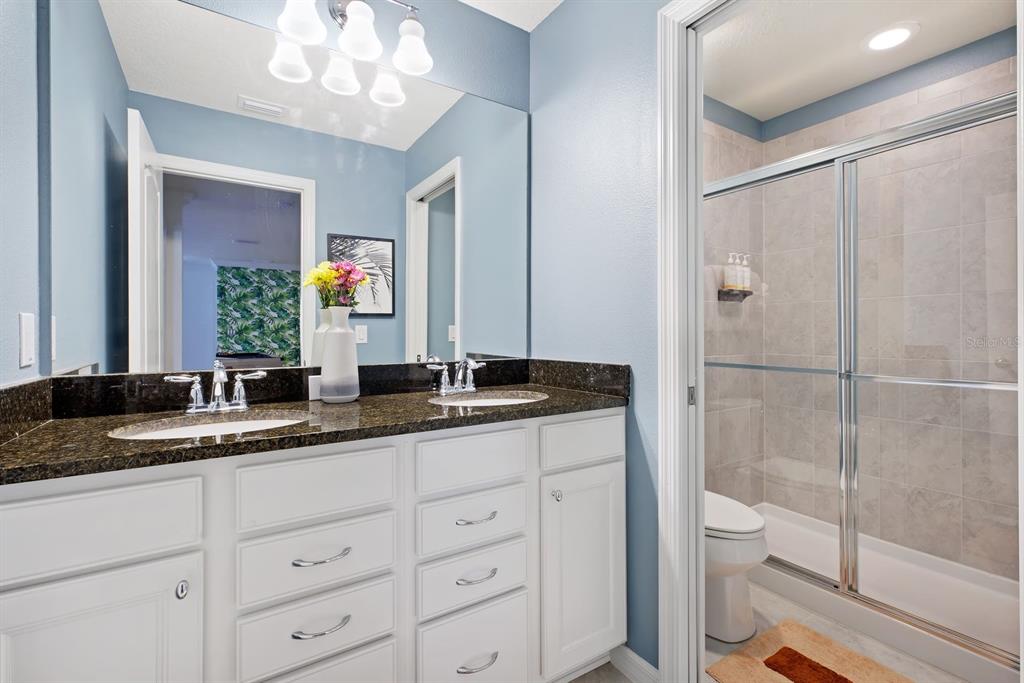 1864 Nice Court Kissimmee, FL 34747 - Photo 15 of 35 a bathroom with a granite countertop sink a mirror and a shower