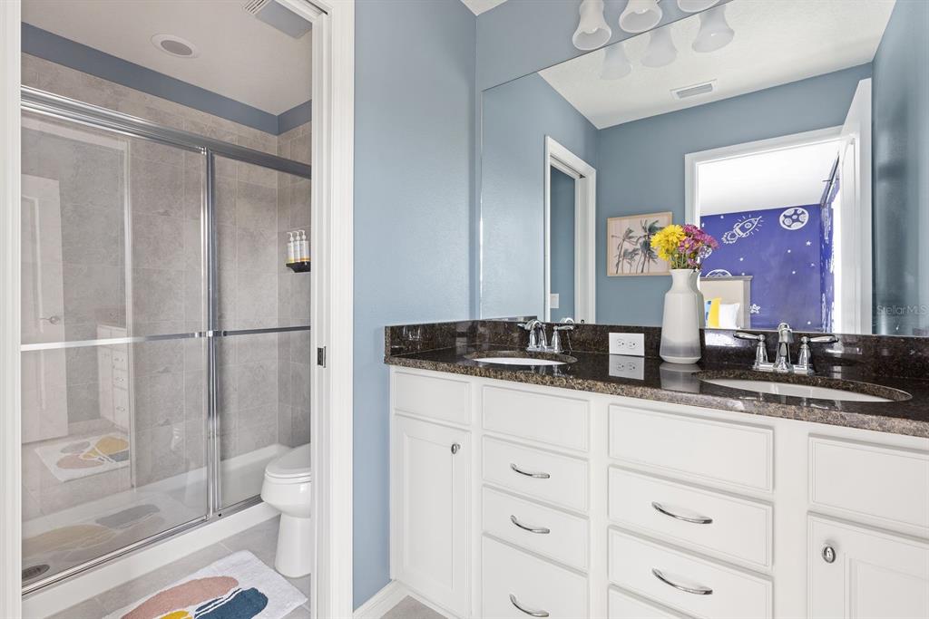 1864 Nice Court Kissimmee, FL 34747 - Photo 25 of 35 a bathroom with a granite countertop sink mirror vanity and toilet