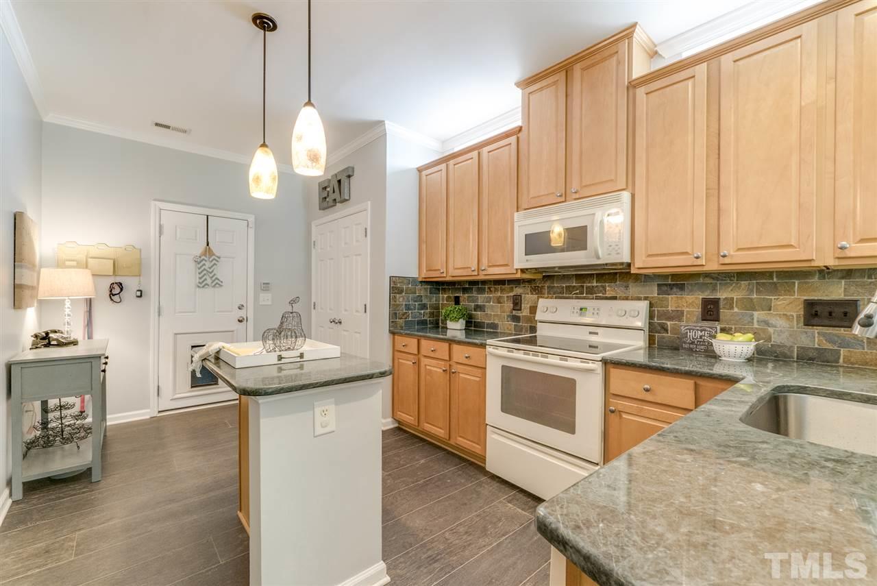 8404 Whisper Ridge Place Raleigh, NC 27613 - Photo 2 of 25 a kitchen with stainless steel appliances granite countertop a sink a stove and a wooden floors