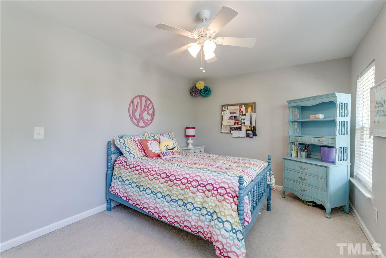 8404 Whisper Ridge Place Raleigh, NC 27613 - Photo 13 of 25 a bedroom with a bed and a chandelier
