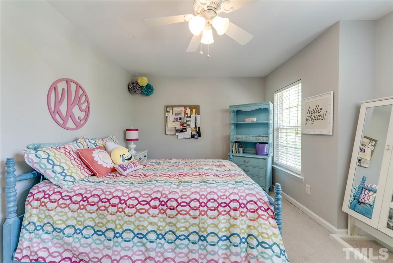 8404 Whisper Ridge Place Raleigh, NC 27613 - Photo 14 of 25 a bedroom with a bed and a chandelier