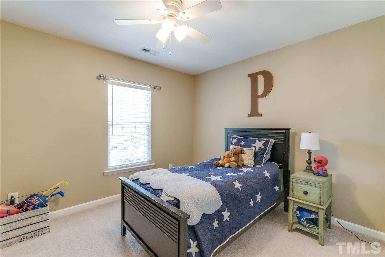 8404 Whisper Ridge Place Raleigh, NC 27613 - Photo 15 of 25 a bedroom with a bed and a chandelier