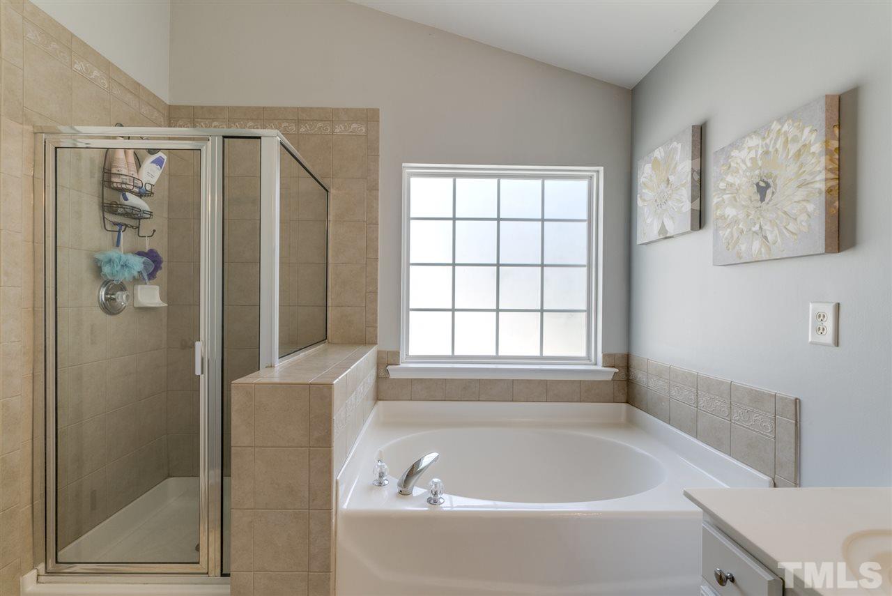 8404 Whisper Ridge Place Raleigh, NC 27613 - Photo 21 of 25 a white bath tub sitting next to a shower