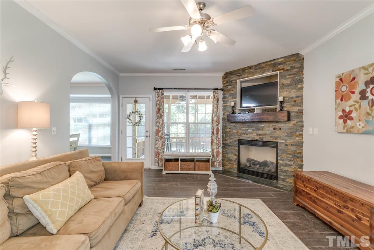 8404 Whisper Ridge Place Raleigh, NC 27613 - Photo 8 of 25 a living room with furniture a flat screen tv and a fireplace